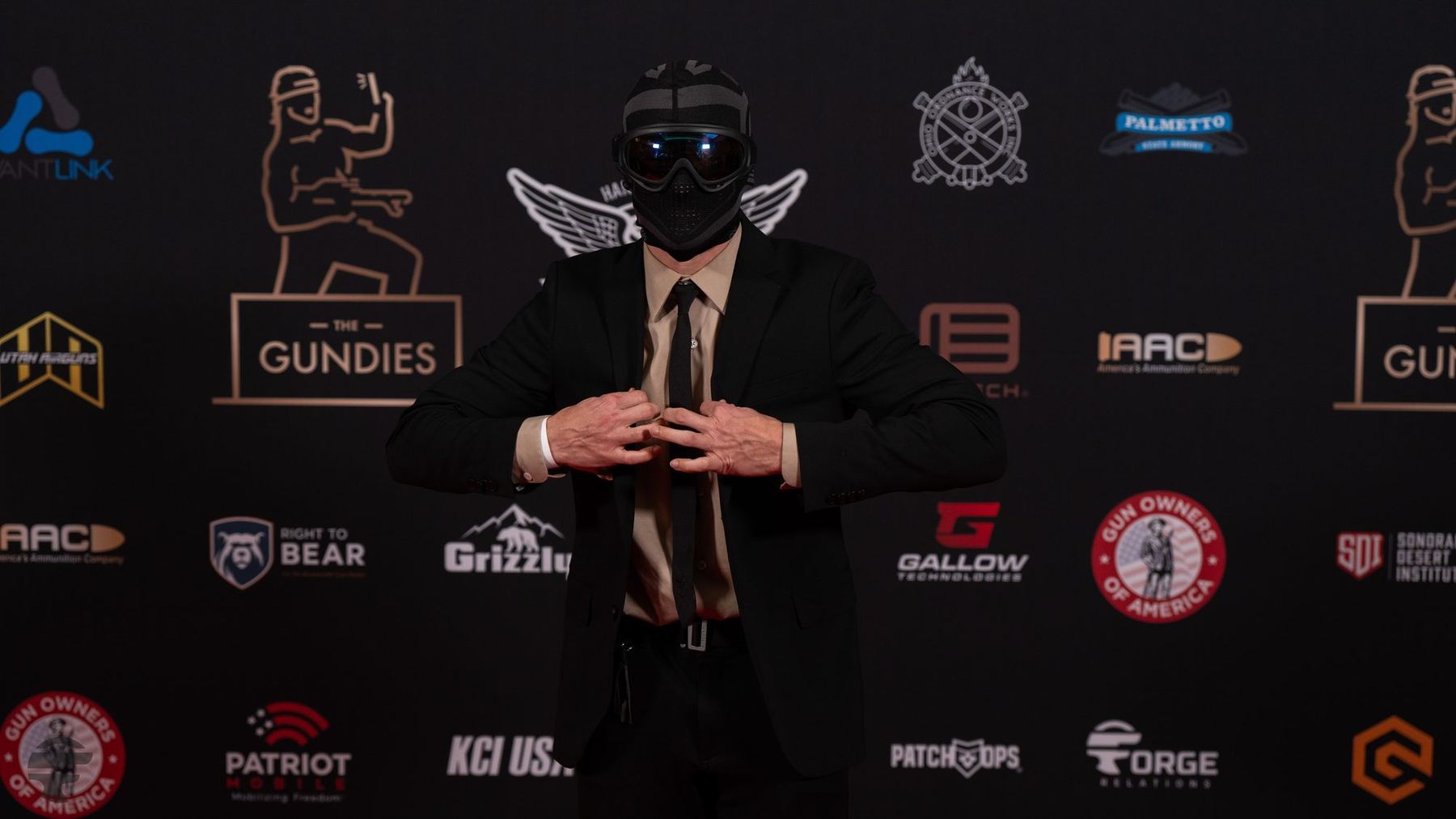 A masked creator on the Gundies 2024 sponsor wall in Las Vegas
