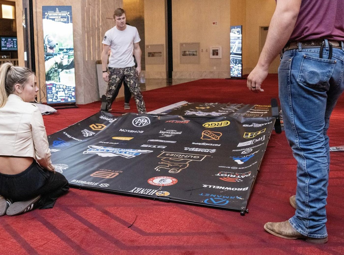 Crew installing the Gundies sponsor step-and-repeat on the red carpet